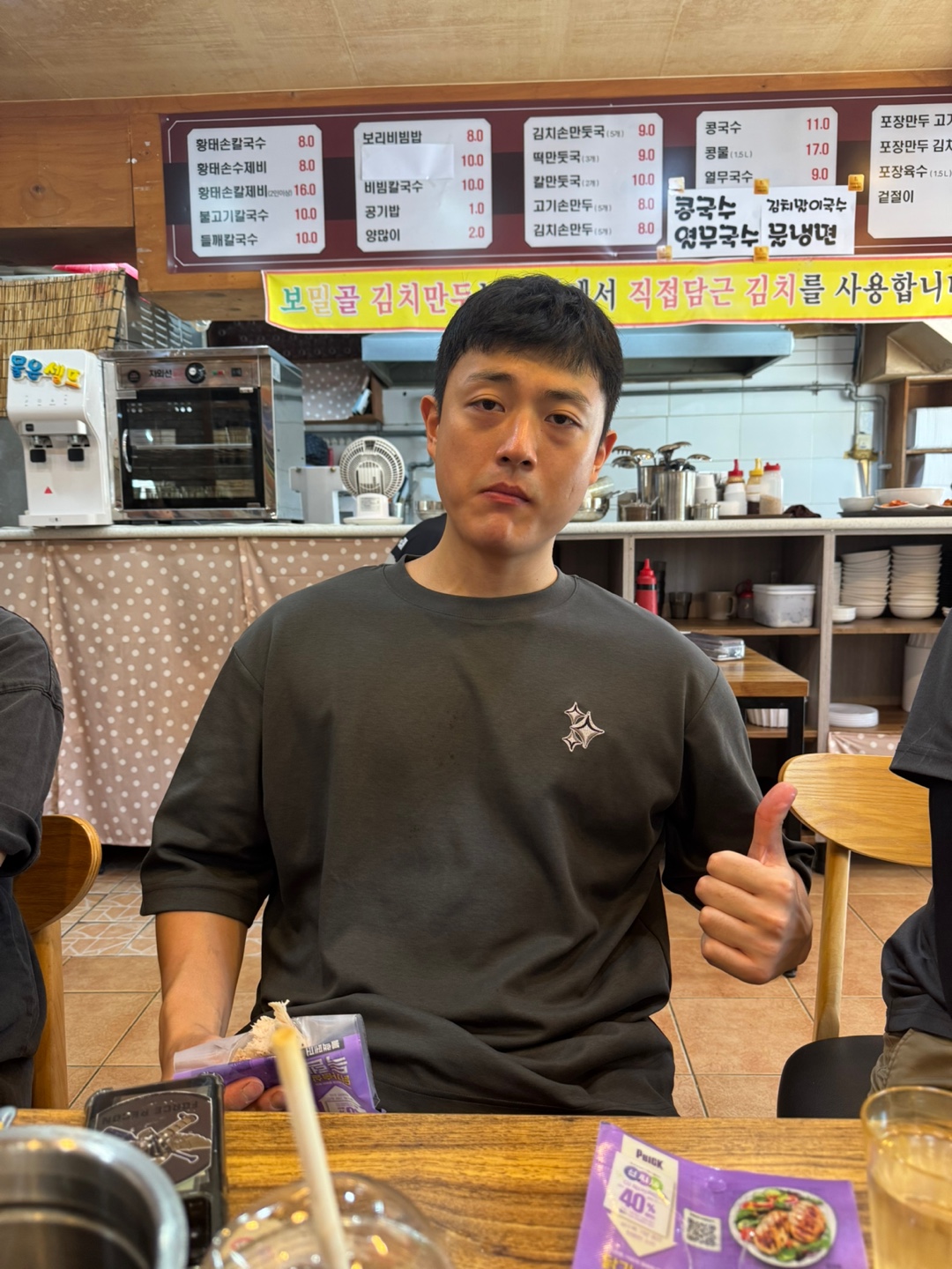 A person wearing a dark embroidered T-shirt at the production location